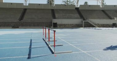 Beyazlı bayan bir sporcunun spor stadyumunda antrenman yaparken yan görüntüsü, koşu pistinde, ağır çekimde. Stadyumda Koşu ve Spor Eğitimi.
