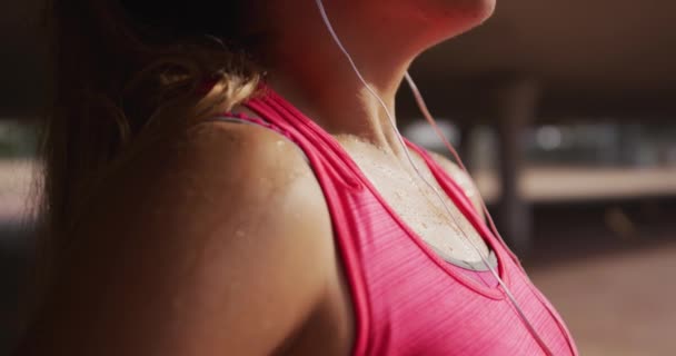 一名身穿运动服 头戴耳机的白人年轻女子在桥下锻炼 动作缓慢时侧视近景 — 图库视频影像