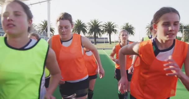 一队年轻的白人女子曲棍球选手在体育场的球场上跑来跑去 在打曲棍球前热身 慢动作 — 图库视频影像