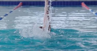 Kafkas erkek yüzücü yüzme havuzunda, yüzme yarışında şeritte yarışırken, sırt üstü yüzerken, ağır çekimde