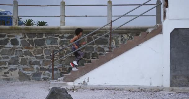 여자가해 변에서 시간을 즐기며 계단을 천천히 — 비디오