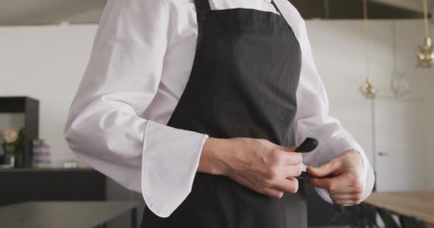 Vue Latérale Une Cuisinière Caucasienne Revêtant Son Tablier Noir Portant — Video