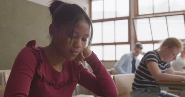 Вид Сбоку Подростка Афроамериканку Школьном Классе Сидящую Столом Улыбающуюся Сосредоточенную — стоковое видео
