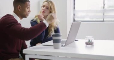 Kafkasyalı bir kadın ve yaratıcı bir ofiste çalışan melez bir adamın bilgisayar ekranına bakıp,