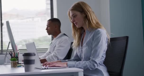 創造的なオフィスで働いている白人女性と混合人種の男の側面図 コンピュータで働いている スローモーション — ストック動画