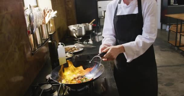 在餐馆厨房的烹饪课上 一个白人女厨师在暖烘烘的锅里煎新鲜蔬菜 然后慢吞吞地把它们燃着 — 图库视频影像