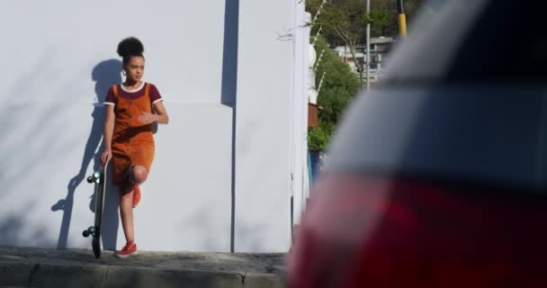 거리에서 시간을 즐기고 여자의 기대어 스케이트보드를 — 비디오