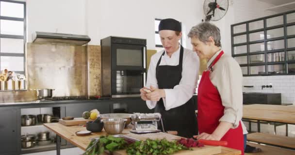 Sidovy Över Äldre Vit Kvinna Och Vit Kvinnlig Kock Matlagningskursen — Stockvideo