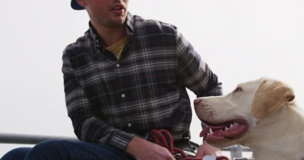 海辺の田舎で犬と散歩を楽しみながら ゆっくりと動きながら犬と話している車椅子の白人男性の正面図 — ストック動画