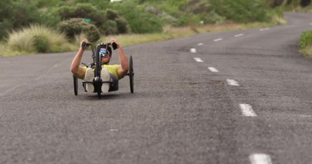 アウトドアスポーツウェアのトレーニングでフィット白人男性のフロントビュー 自転車に乗って 静かな田舎道でサイクリング — ストック動画