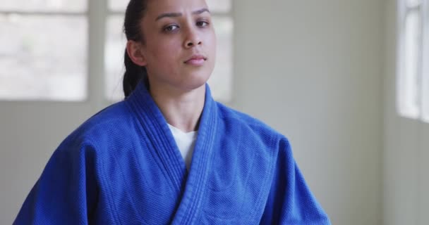 一名身穿蓝色柔道的少年女子柔道选手站在体育馆前慢动作训练的镜头前 — 图库视频影像