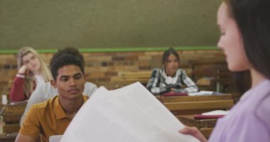 Kafkasyalı genç bir liseli kızın okul sınıfındaki çoklu etnik sınıfa durup kitap okuması, sıralarda oturup, yavaş çekimde dinlemesi ve konsantre olması.