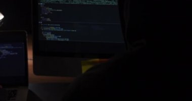 Kafkasyalı bir işadamı ve melez bir iş kadınının geç saatlere kadar modern bir ofiste çalışıp bilgisayar ekranlarına bakarak verileri kontrol etmesi.