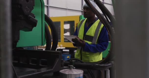 Πλευρική Άποψη Εστιασμένου Αφροαμερικανού Εργάτη Που Εργάζεται Πολυσύχναστη Αποθήκη Εργοστασίου — Αρχείο Βίντεο