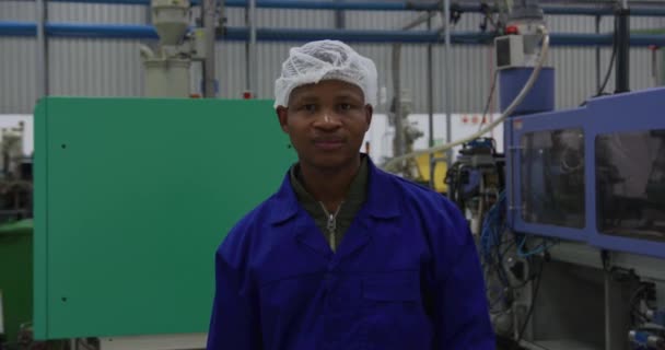 专注的非洲裔美国男性工人的画像 他们站在一家繁忙的工厂仓库里看着相机 戴着发网 面带微笑 — 图库视频影像