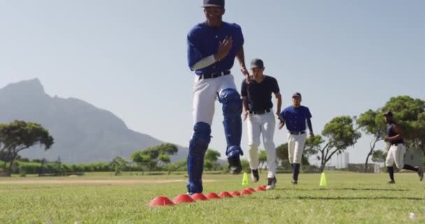 多民族男子棒球队的前景色 在赛前准备 在阳光灿烂的日子里 慢动作地在运动场上锻炼和锻炼 — 图库视频影像