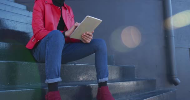 夏季的某一天 一个时尚的变性人成年人在城市里闲逛 坐在街上的楼梯上 用平板电脑慢动作 — 图库视频影像