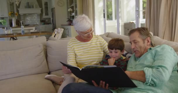 Vooraanzicht Van Kaukasische Grootouders Zittend Een Bank Woonkamer Kijkend Naar — Stockvideo