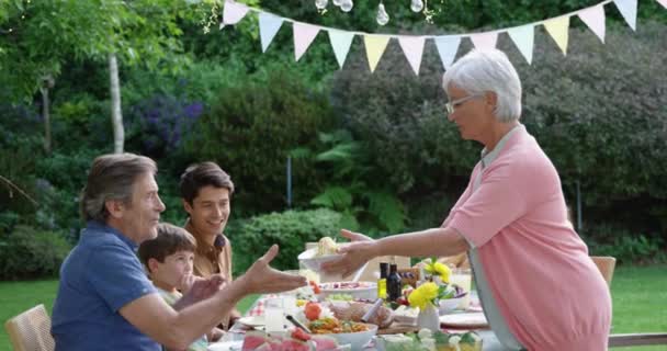 Seitenansicht Einer Kaukasischen Mehrgenerationenfamilie Draußen Einem Für Ein Festmahl Gedeckten — Stockvideo
