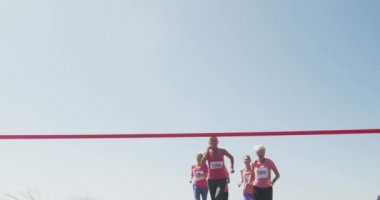 Güneş ışığında eğlenceli koşu yarışı güneşli bir günde kırsalda eğlenen bir grup beyaz kadın arkadaşın yavaş çekimde bitiş çizgisine varıp yarışırken düşük açılı görüntüsü.