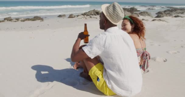 아프리카계 남자와 혼혈아 해변의 양지바른 해변에서 무료로 맥주를 마시고 — 비디오