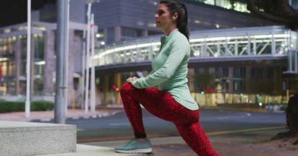 머리에 운동복을 밤에는 밖에서 헤드폰을 따뜻하게 다리를 운동을 여성의 — 비디오