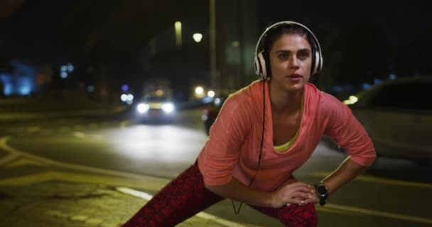 머리에 운동복을 밤에는 밖에서 헤드폰을 따뜻하게 다리를 운동을 여성의 — 비디오