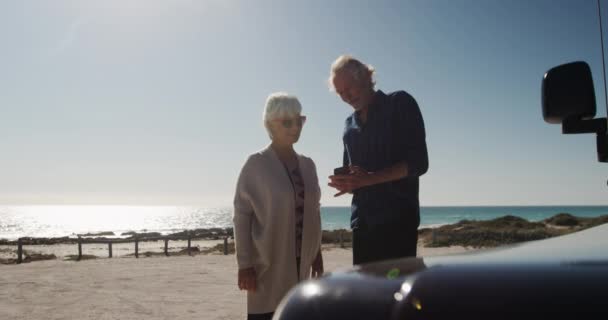 Elölnézet Egy Idős Kaukázusi Pár Strandon Napon Okostelefont Használva Autójuk — Stock videók