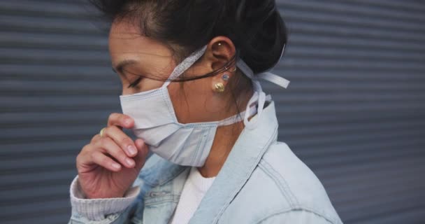 大気汚染やコロナウイルスに対して顔マスクを着用し 咳やスローモーションの背景に灰色の壁の前に立って — ストック動画