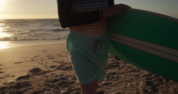 해변에서 일광욕을 즐기고 코카서스 노인의 이보이며 파도타기 바다를 배경으로 동작을 — 비디오