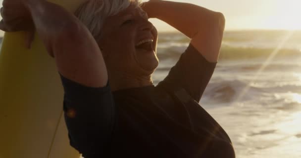 해변에서 파도타기 머리에이고 바다를 배경으로 웃으면서 일광욕을 카프카스 나이많은 여인의 — 비디오
