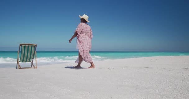 Widok Starszą Afroamerykankę Spacerującą Plaży Obok Leżaka Błękitnym Niebem Morzem — Wideo stockowe