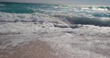 Mavi gökyüzü ve sakin deniz güneşli kumlu bir plajda, ağır çekimde büyük fotokopi alanı ile çekilmiştir.