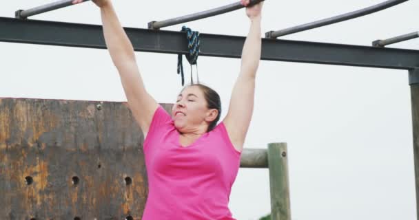 一名身穿粉色T恤的白人女子在训练营 爬上猴栏 慢动作时的侧视图 — 图库视频影像