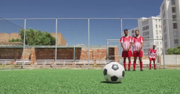 两个多种族的男足队员穿着队服 在阳光下的运动场上训练 打一场比赛 踢任意球 慢动作 — 图库视频影像