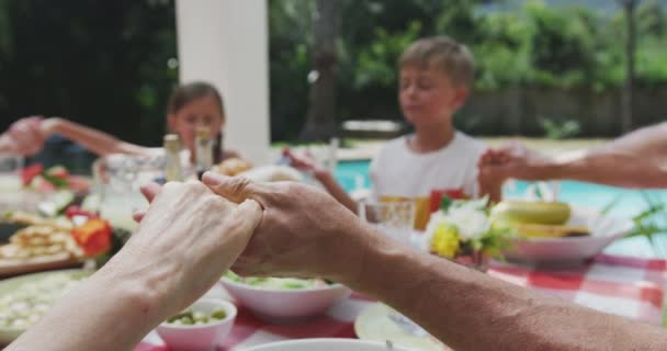 一个多代白人家庭在花园里共度时光 坐在一张桌子旁 慢吞吞地说着优雅的话语 侧景映衬着这个多代白人家庭 — 图库视频影像