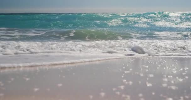 日当たりの良い砂浜の青い空と穏やかな海 大きなコピースペースでスローモーションで撮影 — ストック動画