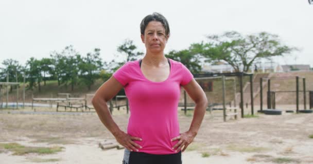 一个自信的混血女子站在新兵训练营 双手托着臀部 身穿粉色T恤 慢动作的画像 — 图库视频影像