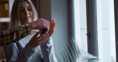 Karışık bir ırk adamıyla beyaz bir kadının evde birlikte vakit geçirmesinin yan görüntüsü. Kahve getiren, kucaklayan, öpen ve pencereden dışarı bakan adam..