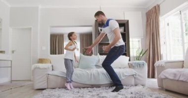 Kafkasyalı bir adamın dairede vakit geçirmesinin zevkini çıkarırken, kızıyla dans ederken, ağır çekimde.