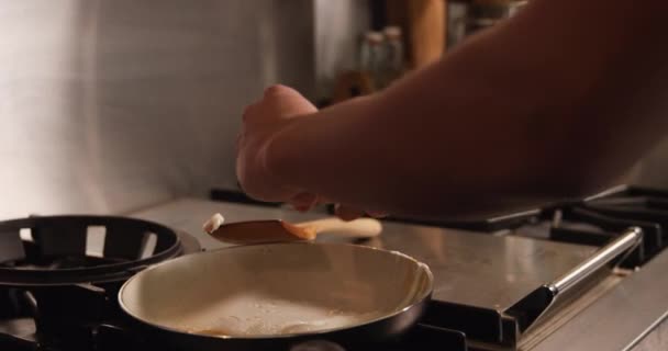 朝食のためのフライパンで目玉焼きを準備彼の台所に立って 混合レースの女性の側のビューのセクション — ストック動画