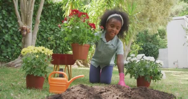 Vista Frontal Uma Menina Afro Americana Divertindo Jardim Ajoelhando Colocando — Vídeo de Stock