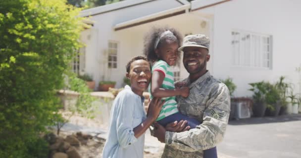 アフリカ系アメリカ人の家族の庭での時間を楽しんでいる側のビューでは 男が軍の制服を着ている 彼の娘を保持し カメラを見て 晴れた日には スローモーションで — ストック動画