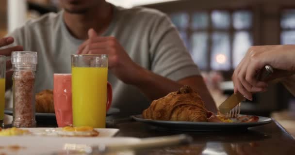 混合人種の男と白人女性のフロントビューの中央部 一緒に家で時間を楽しんで キッチンテーブルに座って 朝食を食べます — ストック動画