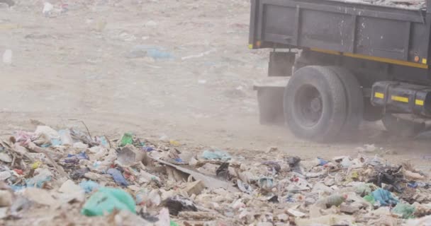 货车驶过堆在堆满垃圾的堆填区的垃圾时的侧视图 车辆缓慢地在后面工作和清理垃圾 — 图库视频影像