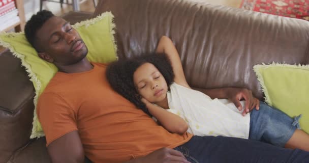 アフリカ系アメリカ人の男と彼の混合レースの娘のフロントビュー一緒に家で時間を楽しんで ソファの上に横たわって 睡眠と抱擁 スローモーションで — ストック動画