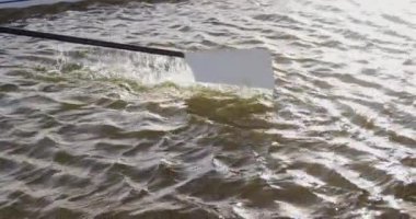 Güneşli bir günde, yavaş çekimde, suya girip çıkan beyaz bir küreğin detaylarını kapat.