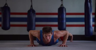 Kafkas erkek boksör ve karışık ırktan erkek boksör boks salonunda şınav çekiyorlar, ağır çekimde. Ticari mutfakta çalışmakla meşgul şefler..