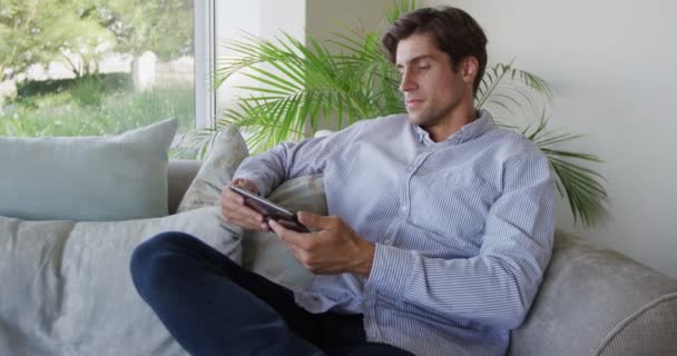 Vista Lateral Hombre Caucásico Disfrutando Tiempo Apartamento Sentado Sofá Sosteniendo — Vídeo de stock