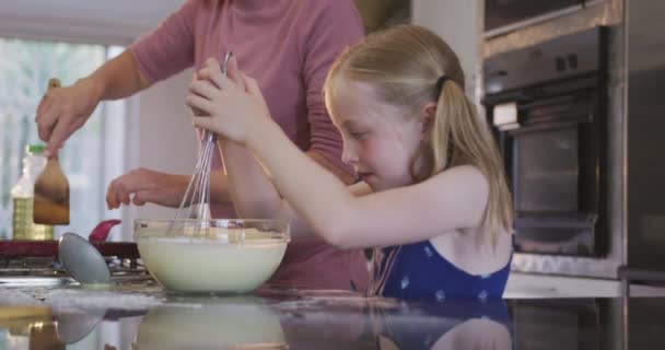 家庭で娘と一緒に家族の時間を楽しんで幸せな白人女性 パンケーキを作り 彼らの台所で笑顔 隔離されたロックダウンでの社会的距離と自己分離 スローモーションで — ストック動画